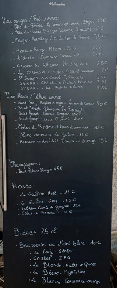 Menu écrit sur une ardoise avec différents plats et prix.