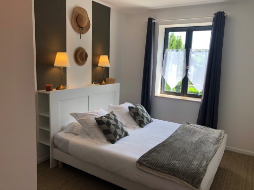 Chambre moderne avec lit double, décor minimaliste et luminaires doux.
