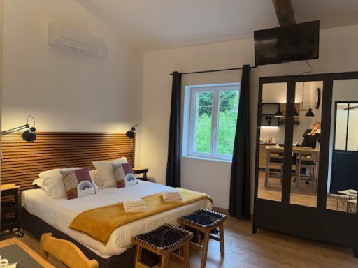 Chambre moderne avec un lit double, fenêtres et coin salon.