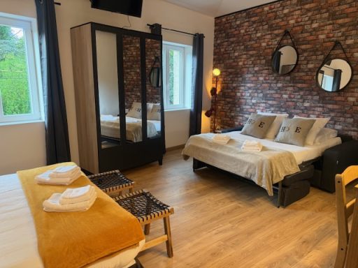 Canapé convertible déplié en lit avec véritable matelas confortable, idéal pour un couchage quotidien dans un gîte tout confort.